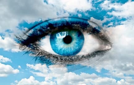 A blue eye blended into a sky full of clouds