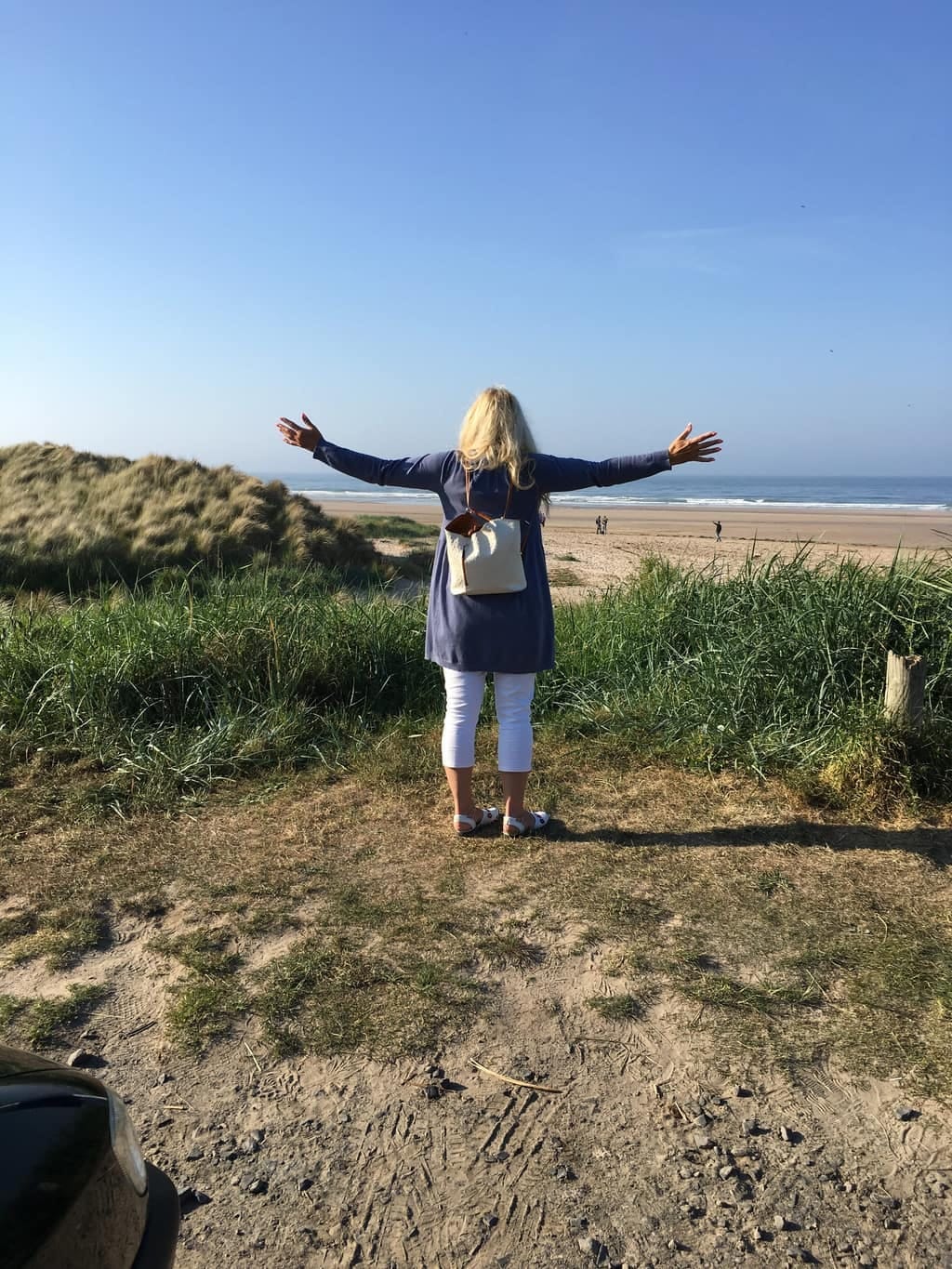 Woman on a beach with her arms stretched out