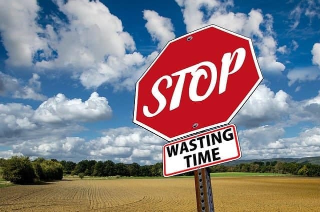 Stop procrastinating Road sign reading stop wasting time